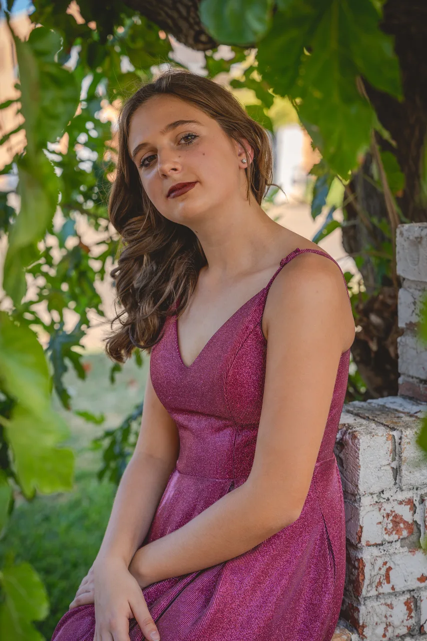 A portrait of a young woman framed by green leaves