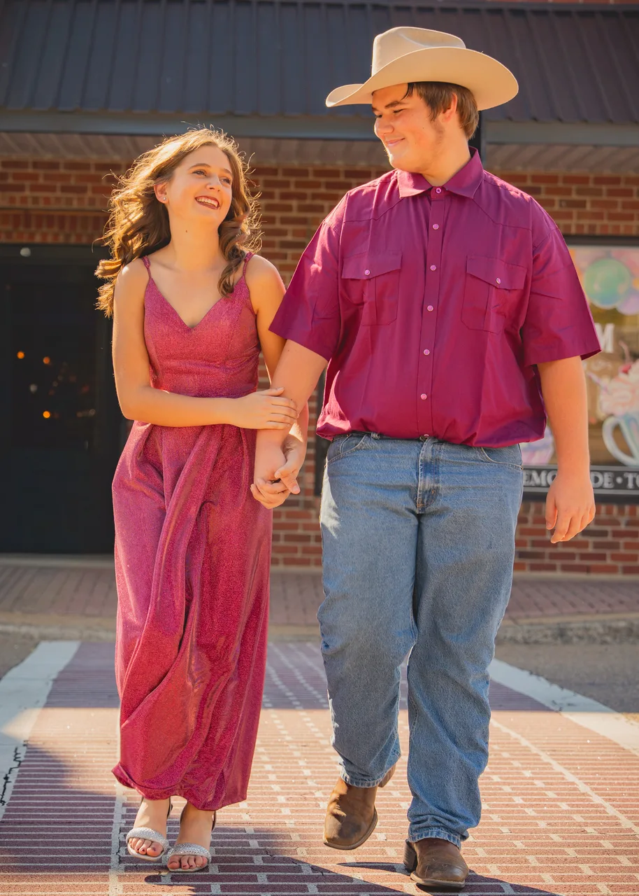 A couple holding hands and laughing as they walk downtown
