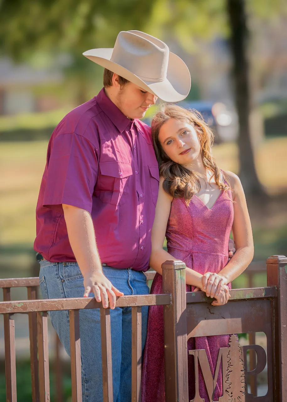 A couple leaning on a bridge gate in soft light
