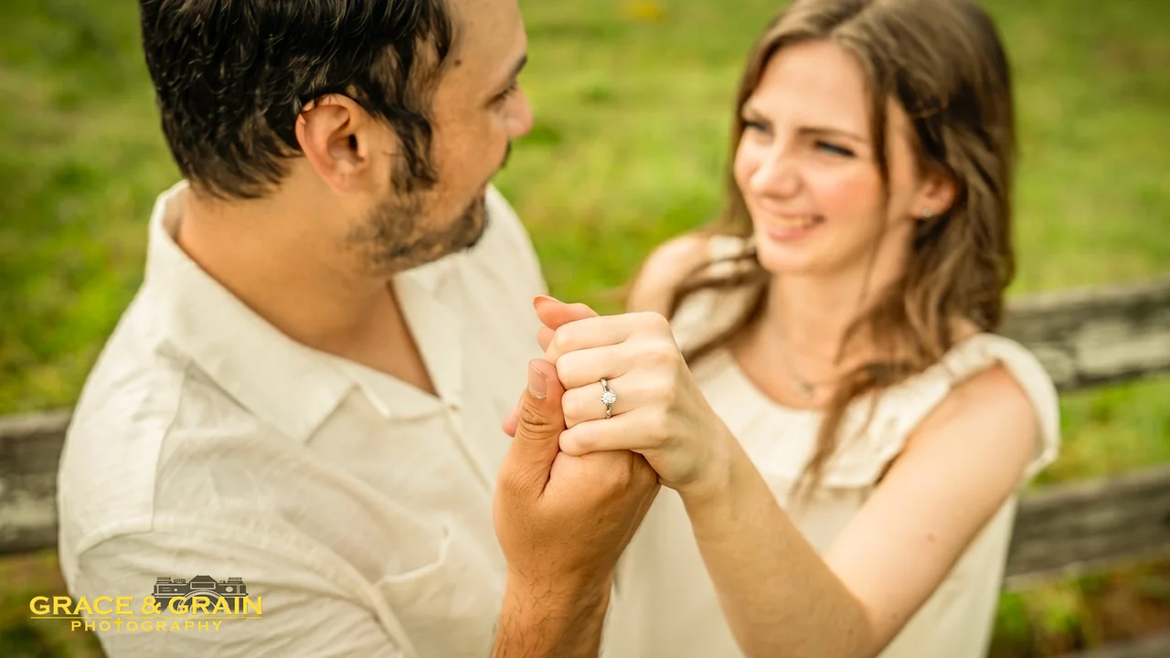 A couple holding hands, the engagement ring in focus