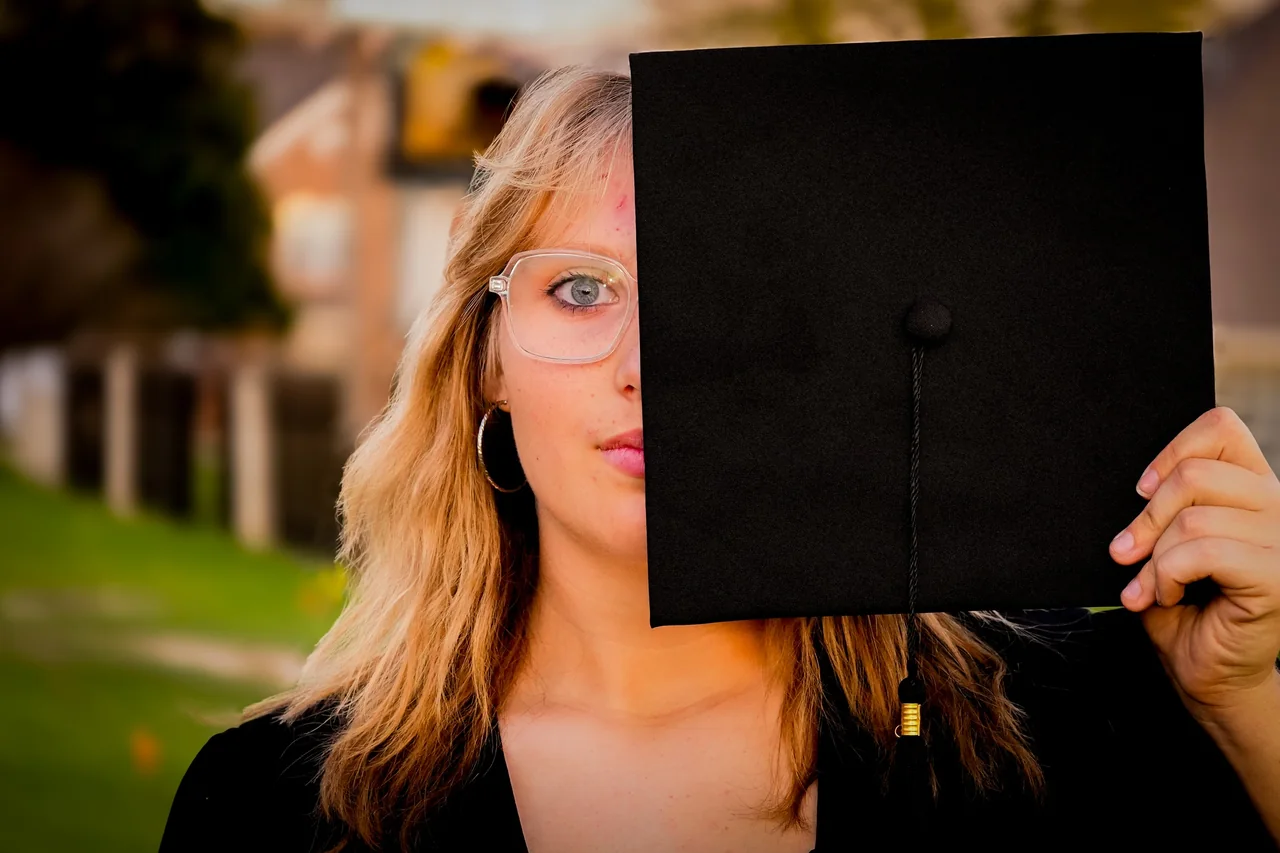 A graduate peeking out from behind her mortarboard